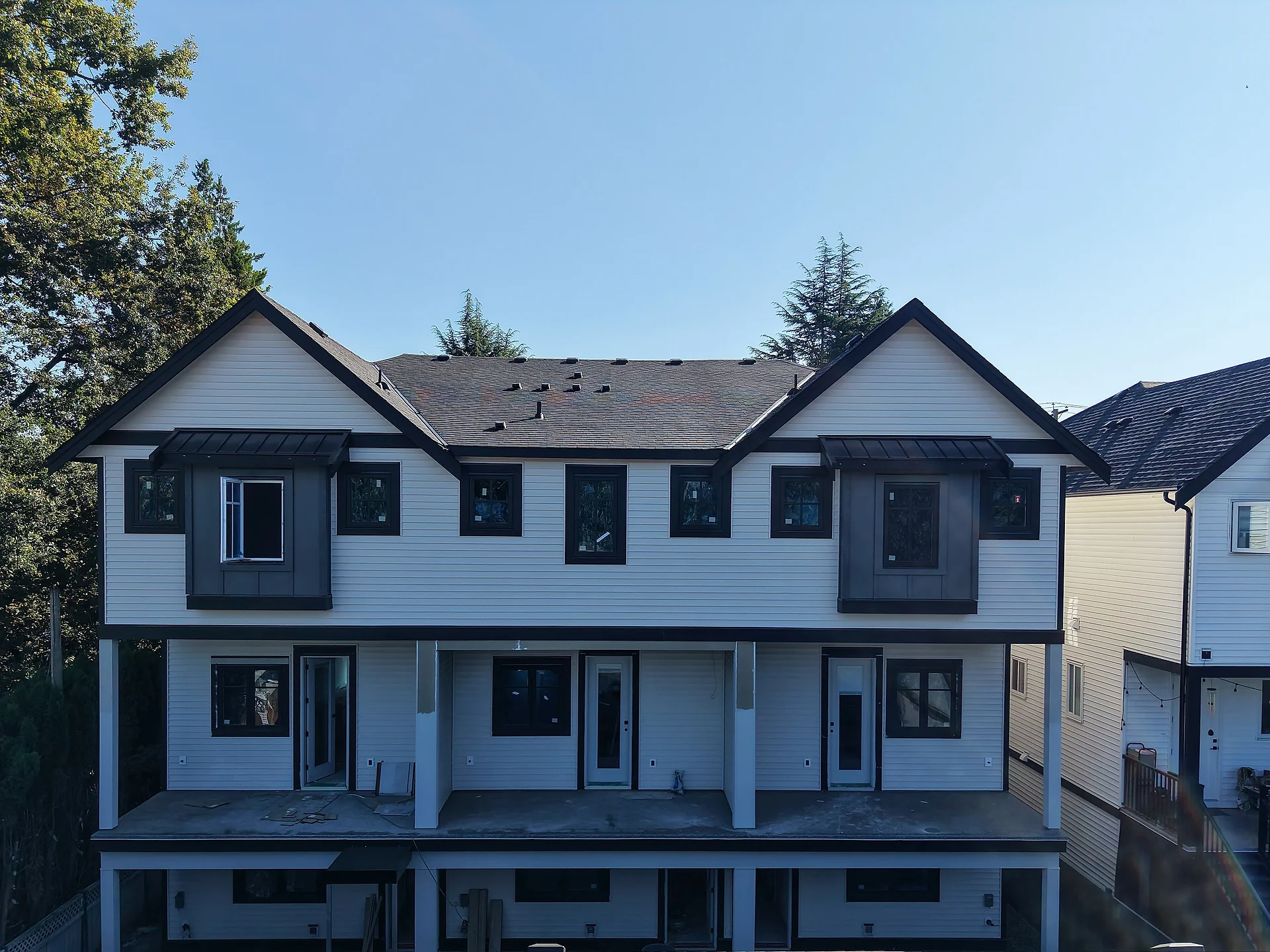 Rear townhouse block in cream lap siding with grey panel dormers, from the air, Abbotsford BC