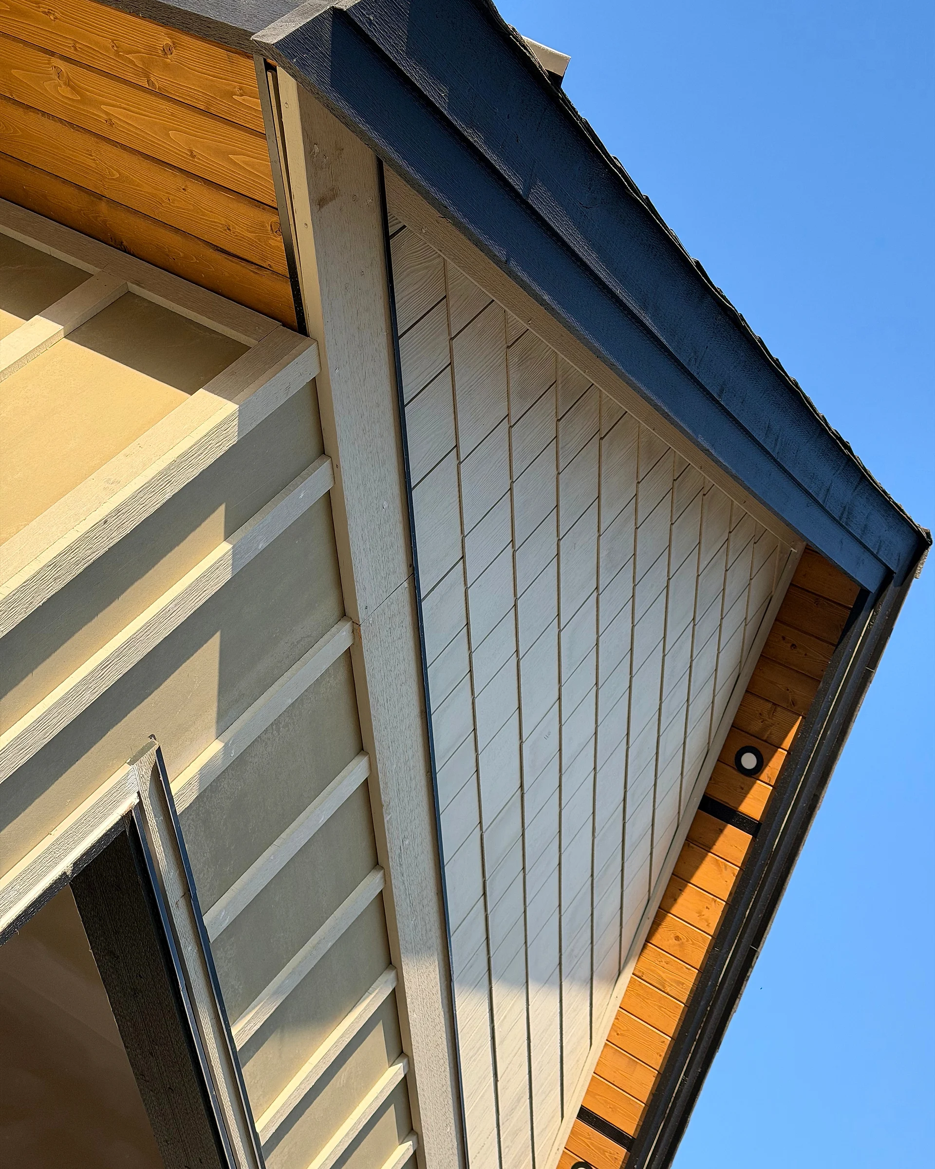 Shake gable, clear cedar soffit and board-and-batten siding meeting at the eave, Langley BC