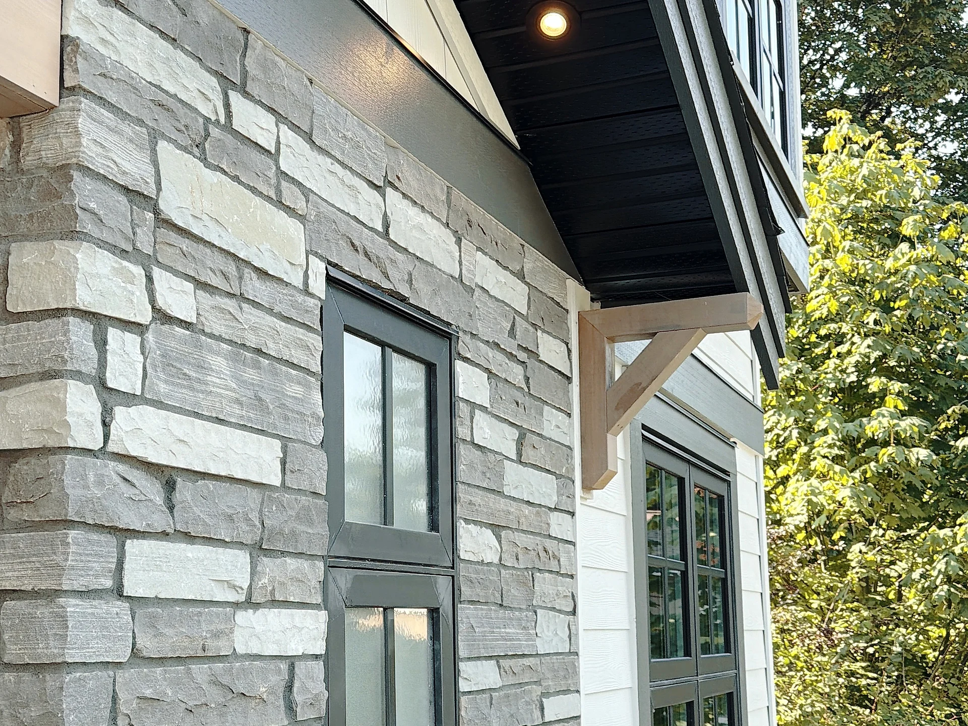 Black-framed window set into the stone-veneer base, Burnaby BC