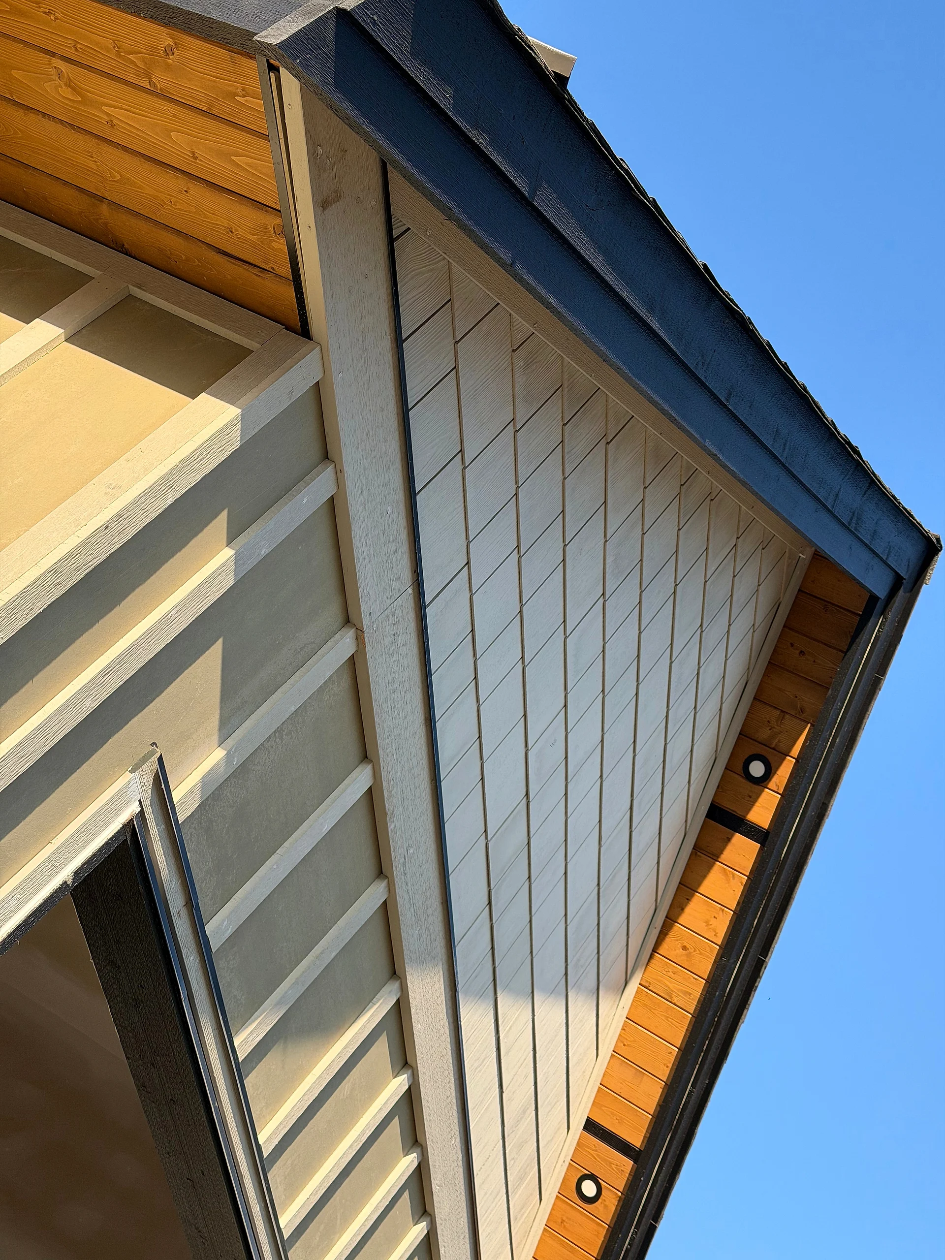 Shake gable, clear cedar soffit and board-and-batten siding meeting at the eave, Langley BC