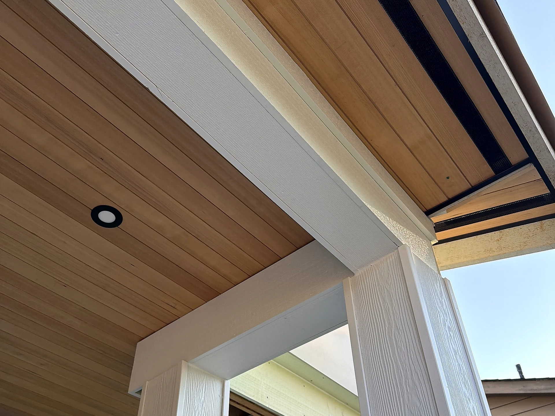 Clear cedar porch ceiling with recessed lights and wrapped beam, North Vancouver BC