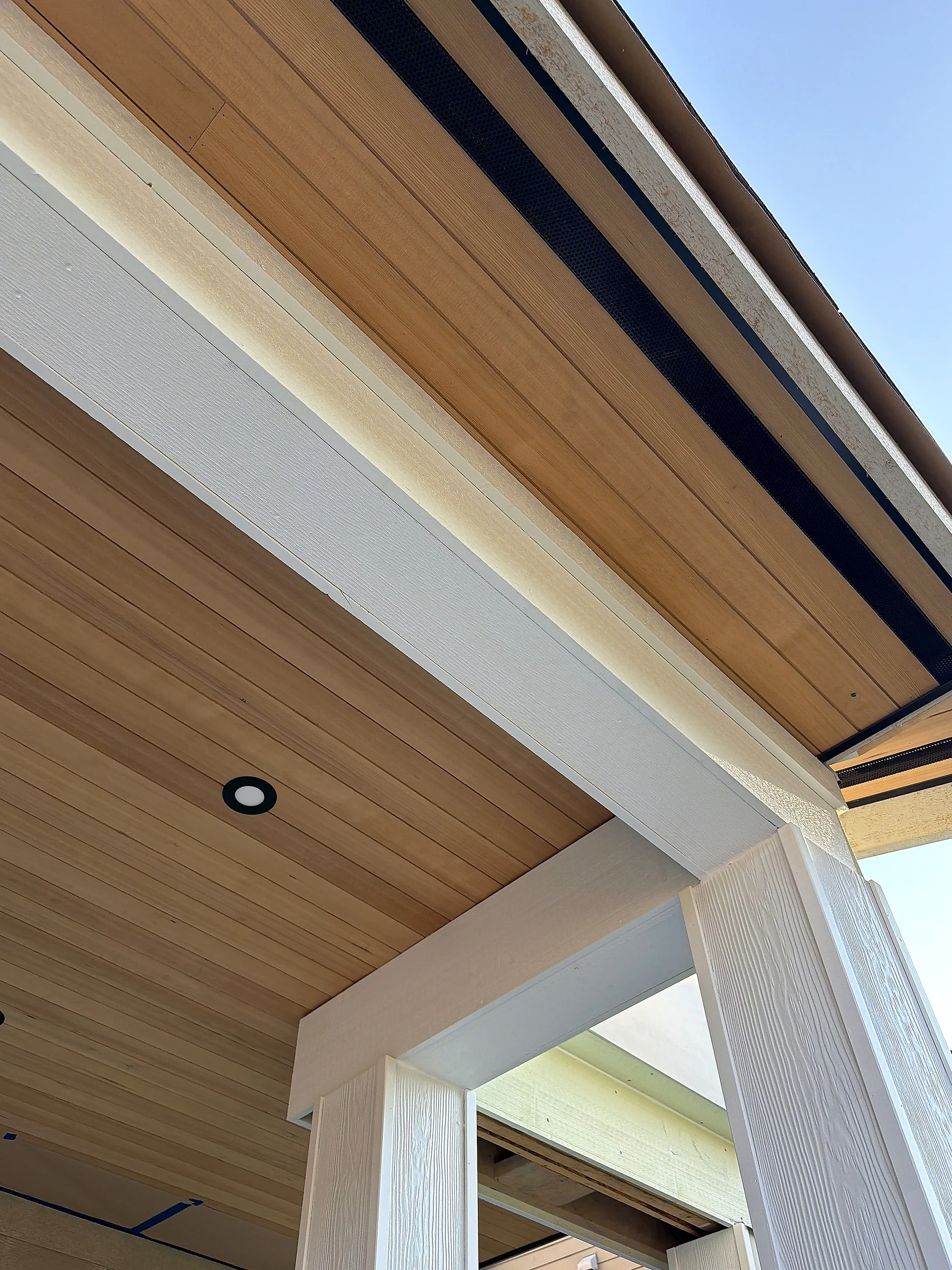 Clear cedar porch ceiling, white fascia and wrapped beam at the porch edge, North Vancouver BC