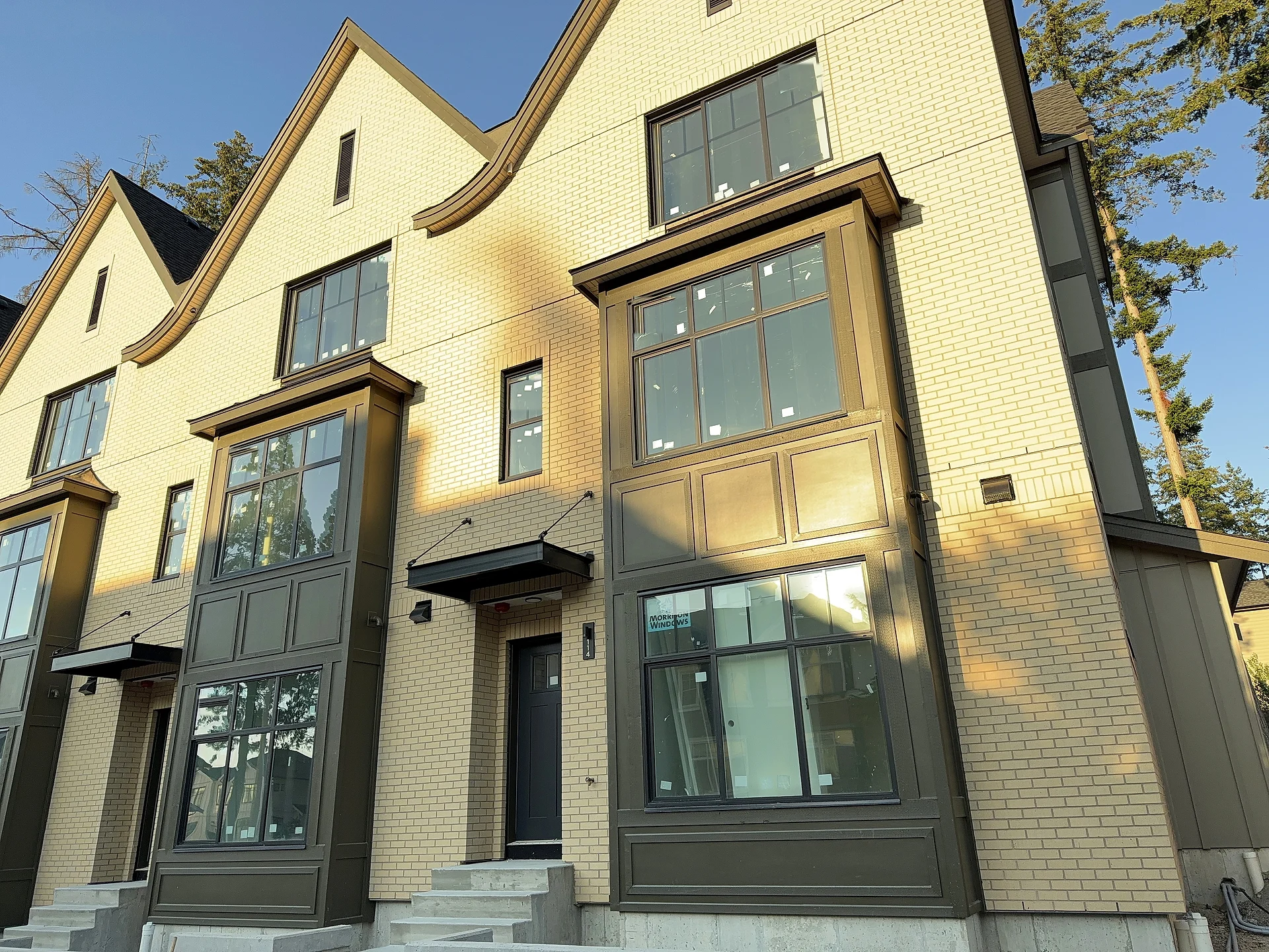 Brick townhouse row elevation with dark panel bay stacks, South Surrey BC