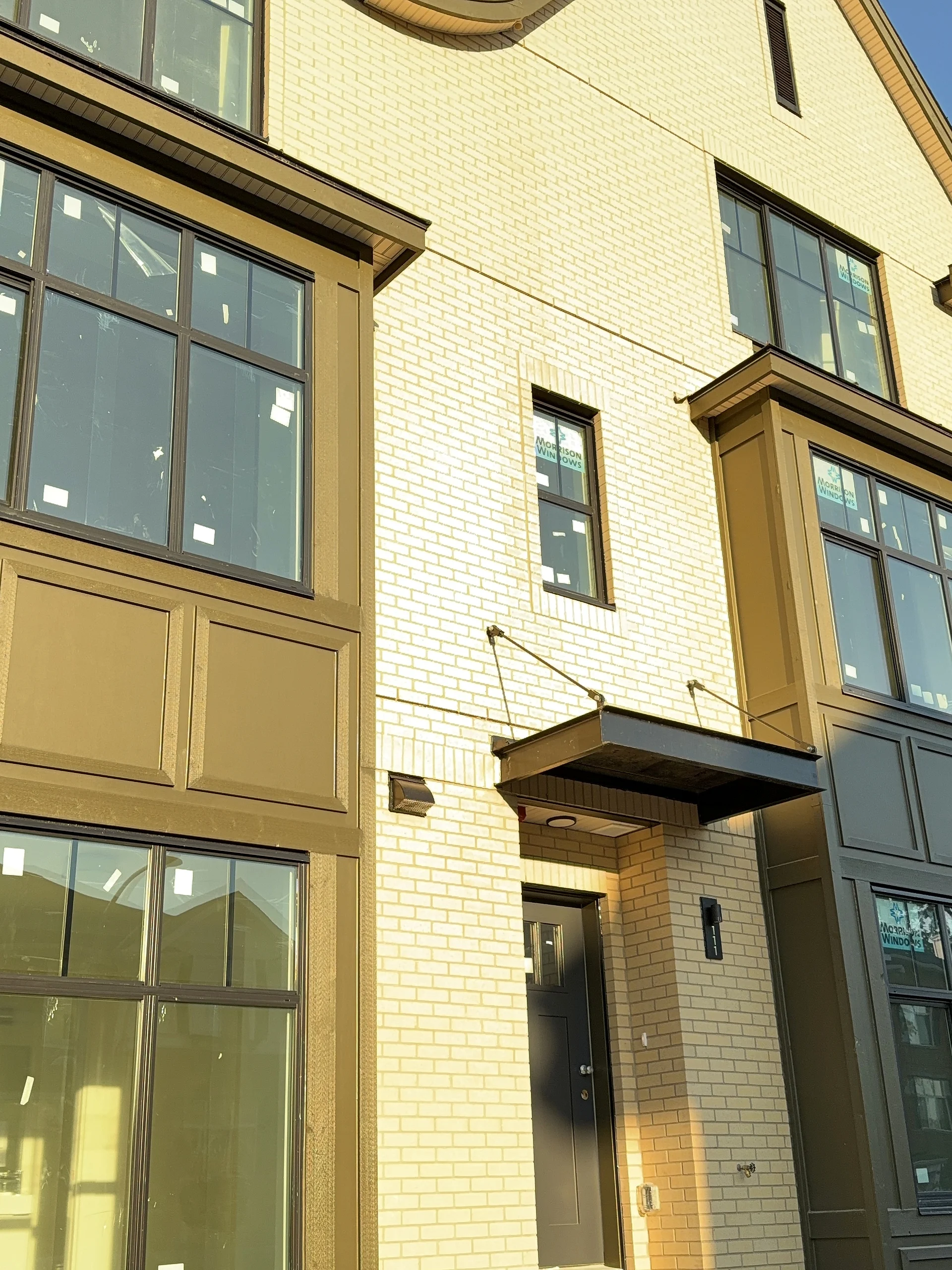 Townhouse entry with black canopy, panel bay above, South Surrey BC