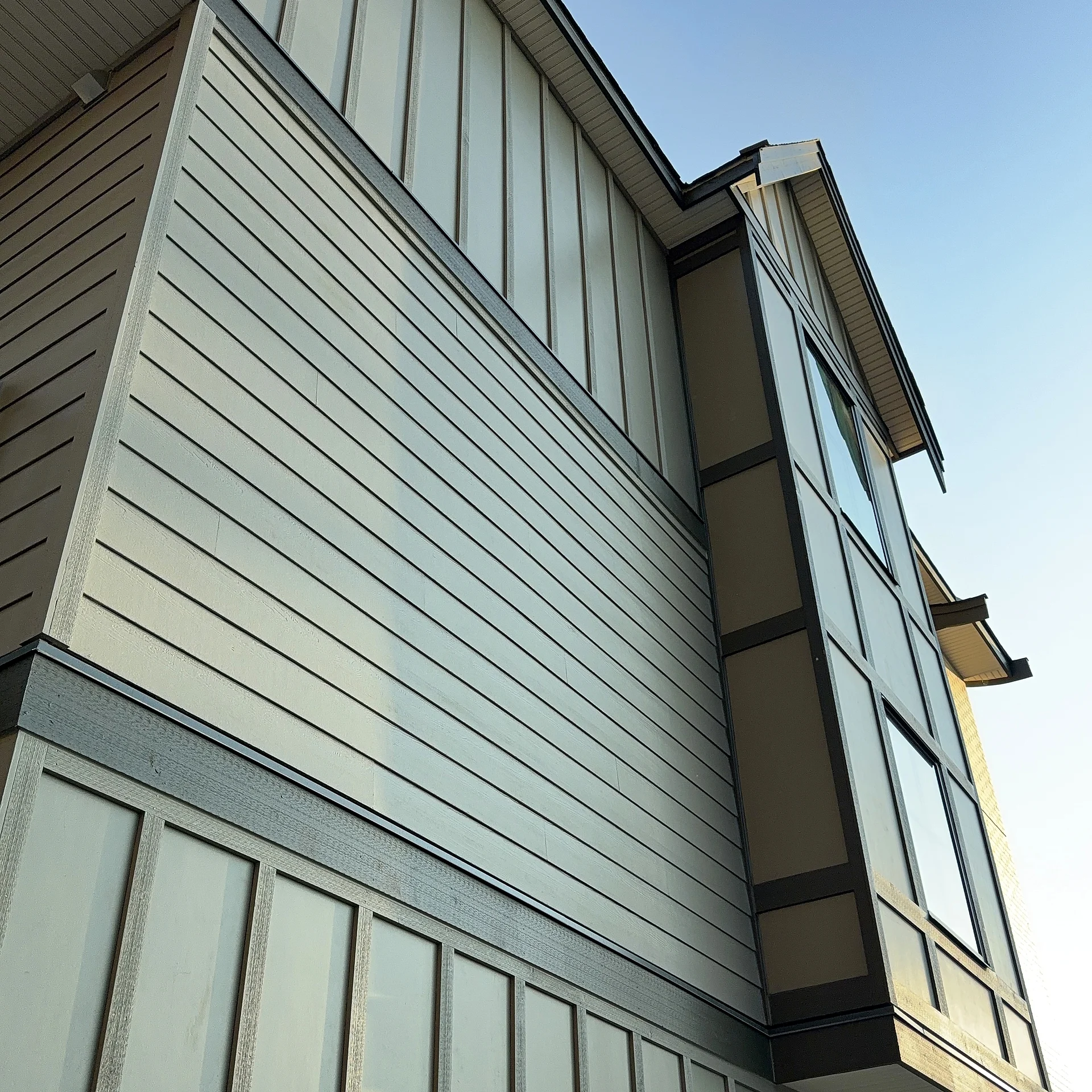 Corner of a panel-clad bay meeting brick, South Surrey BC