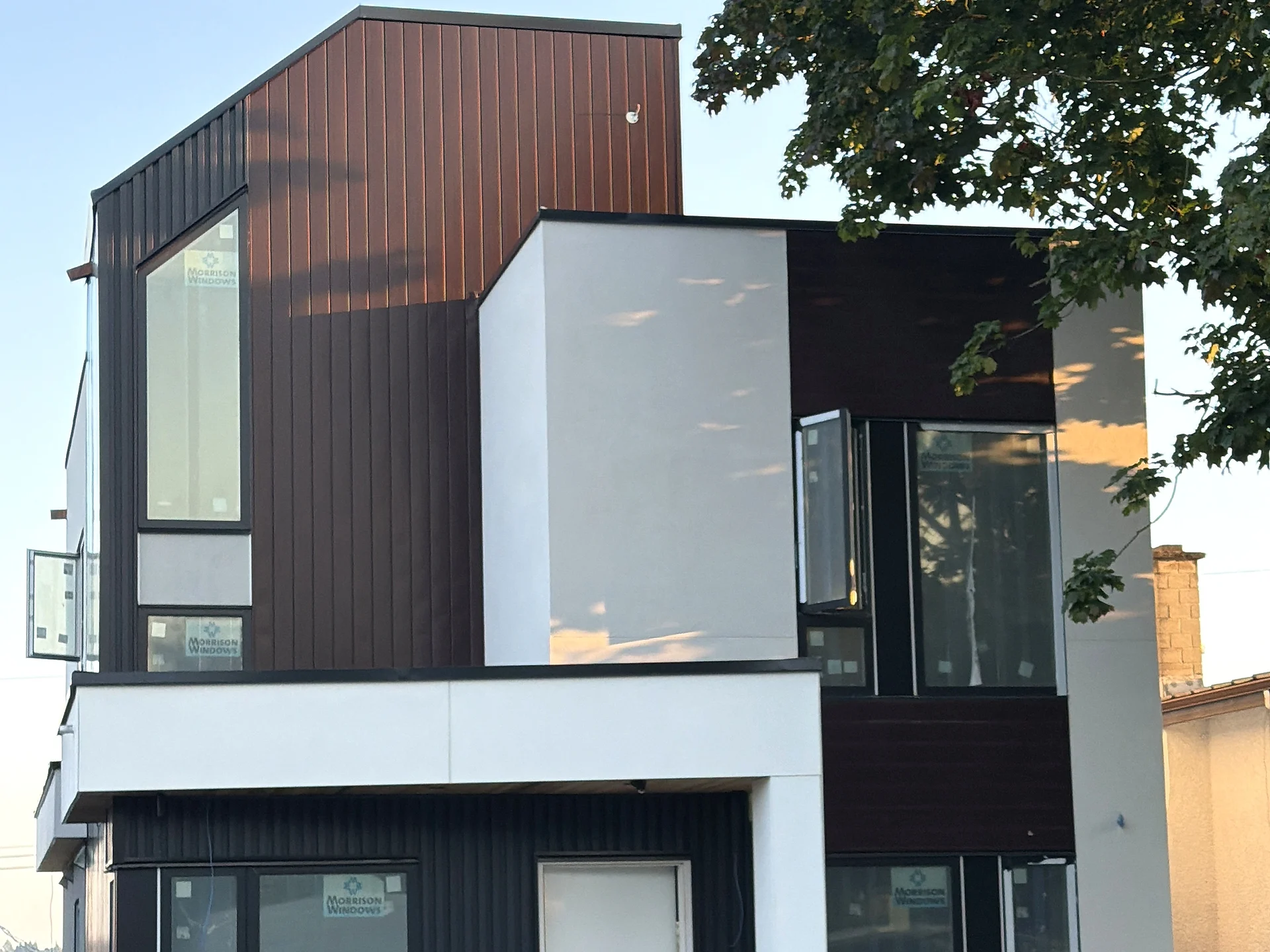 Corner of a modern infill home, black cladding meeting white panel, Vancouver BC