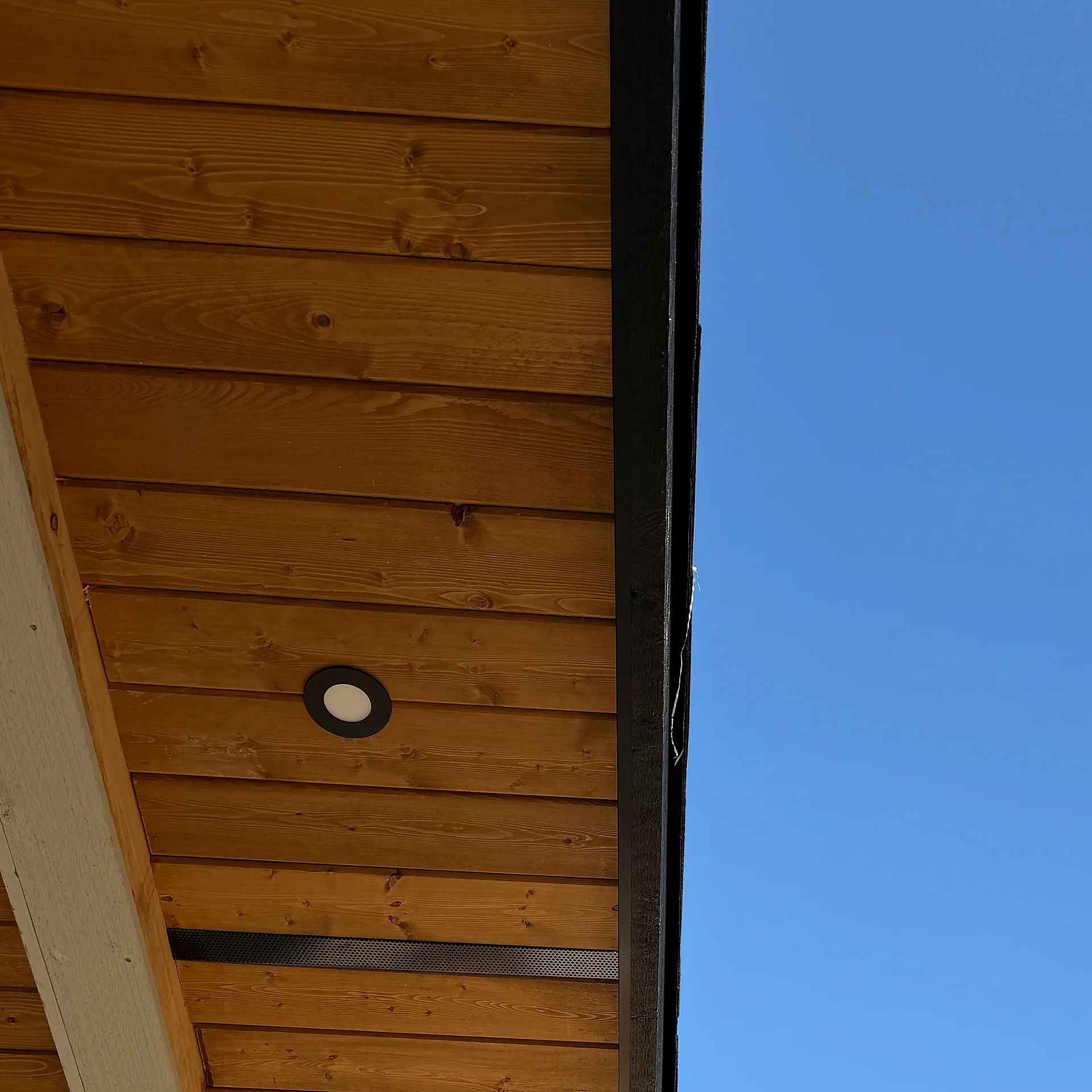 Cedar soffit and black fascia at an eave corner, Langley BC custom home