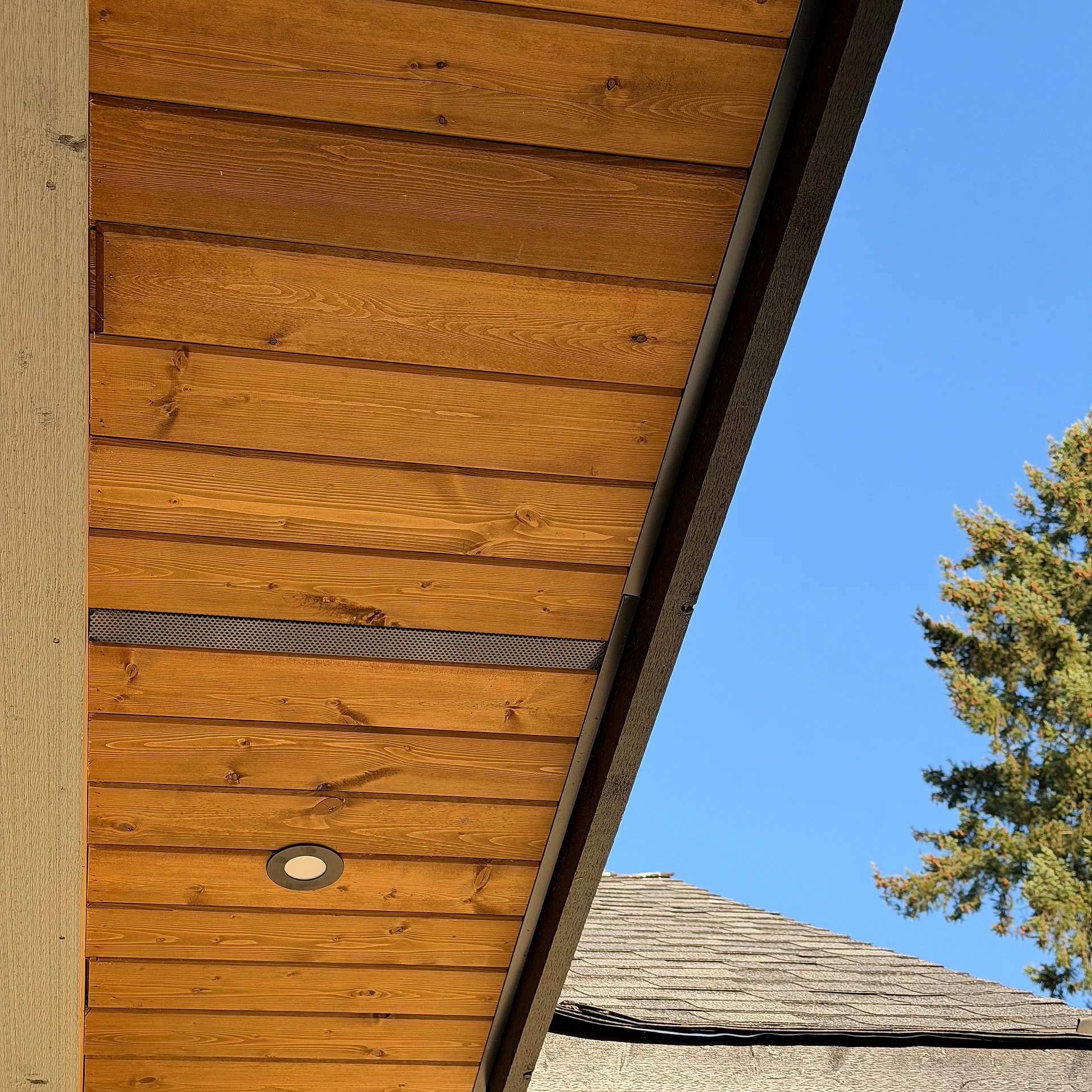 Vented cedar tongue-and-groove eave soffit with continuous vent strip and pot light, Langley BC